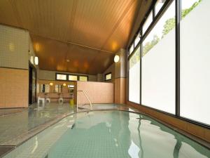 a swimming pool in a building with windows at Iwaizumi Ryusendo Hotel Ryunosumika in Iwaizumi