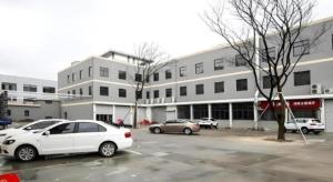 a white car parked in a parking lot in front of a building at Jinjiang Inn Style Xiangshan Bus Station in Xiangshan
