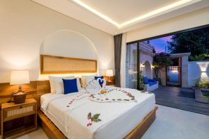 a bedroom with a large white bed and a balcony at Diwangkara Villa Pandawa in Ungasan +20 photos