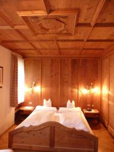 een slaapkamer met een groot bed en een houten plafond bij Chalet Ciasa Alexander in San Cassiano