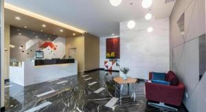 a lobby with a counter and a table and chairs at Borrman Hotel Wuxi Hubin Business Street in Wuxi