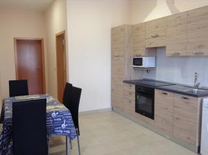 a kitchen with a table and a microwave at Casa Mao-Cheia in Arco da Calheta