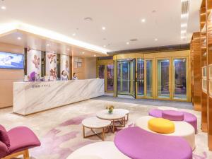 济南Lavande Hotel Ji'nan Railway Station Long Distance Bus Terminal的大堂设有紫色和黄色的椅子和柜台