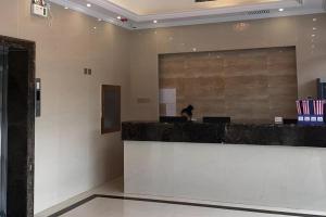a person sitting at a counter in a lobby at City 118 Hotel Aodele in Songguantun