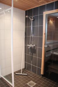 e bagno con doccia e parete piastrellata. di Villa Ilves A a Syöte Altre 21 foto