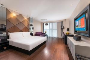Giường trong phòng chung tại Orange Hotel Suzhou Xiangcheng Avenue Global Harbor