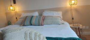 een bed met drie kussens erop en twee lampen bij Casa Mahana spa in Saugnacq-et-Muret