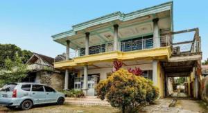 a car parked in front of a house at Hotel O Penginapan Aina Syariah in Rantaupanjang
