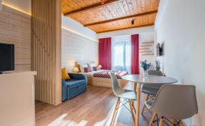 a living room with a blue couch and a table at NEO Skyview Suites in Gudauri