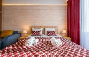 a bedroom with a large bed with towels on it at NEO Skyview Suites in Gudauri