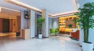 a lobby with plants and chairs in a building at Jinjiang Inn Wuhan Linjiaohu Wanda Branch in Wuhan