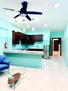a kitchen with blue walls and a ceiling fan at Hotel Sea Queen Suite & Golf Cart Rental in San Pedro +52 photos