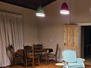 a dining room with a table and chairs and lights at Arrosa Guesthouse in Vrede