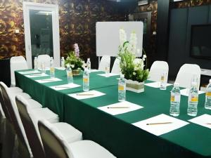 a long green table with white chairs and bottles of water at 900 Inn in Bintulu