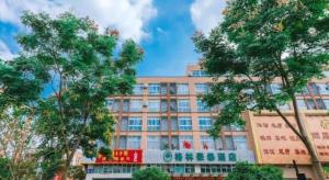 a large building with trees in front of it at GreenTree Inn Jiaxing Zhongan Business Hotel in Jiaxing