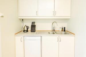 Una cocina con gabinetes blancos y un fregadero. en Delightful Bryggen Apartment - Norwegians Minimum Age 25, en Bergen 10 fotos más