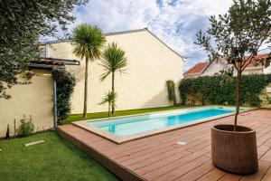una piscina en un patio con una palmera en Suite dans une échoppe, en Bègles
