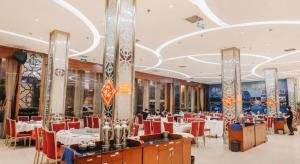 uma sala de jantar com cadeiras vermelhas e mesas num restaurante em 7 Days Inn Wuhan Huaqiaocheng Happy Valley em Wuhan