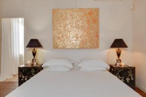 Un dormitorio con una cama blanca con dos mesitas de noche. en Suite dans une échoppe, en Bègles 21 fotos más