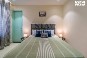 ein Schlafzimmer mit einem großen Bett und blauen Kissen in der Unterkunft StayVista at The Vara House with AC & Board Games in Varanasi