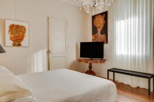 Un dormitorio con una cama y un televisor de pantalla plana. en Suite dans une échoppe, en Bègles