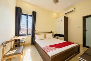 a bedroom with a bed and a table and a window at Dũng Quyến Homestay in Da Nang