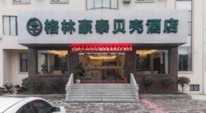 GreenTree Inn Wuxi Donggang Town Donghutang Shell Hotel في ووشي: مبنى به لافتة على واجهته