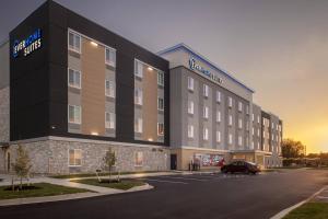 Everhome Suites Bowling Green في بولينغ غرين: مبنى فيه سيارة متوقفة في موقف للسيارات