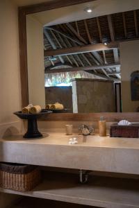 a bathroom with a sink and a large mirror at Nomadic Resort Bali in Canggu