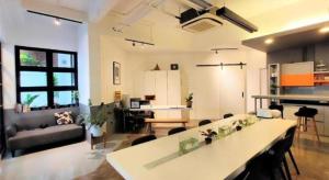 Una gran sala de estar con una mesa y un sofá. en Silom Studios, en Bangkok