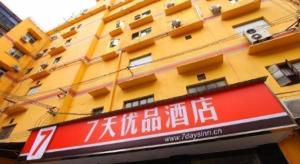 a yellow building with a sign in front of it at 7 Days Premium·Yichang CBD Business Center in Yichang