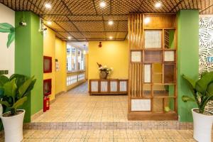 a hallway of a building with green and yellow walls at TRIPLE Riverside Villa Hotel HoiAn in Hoi An +192 photos