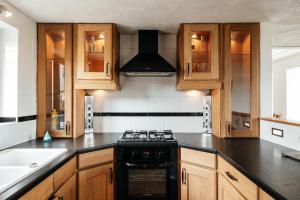 a kitchen with wooden cabinets and a stove top oven at Le Logis du Vieux Donjon in Châteaumur +23 photos