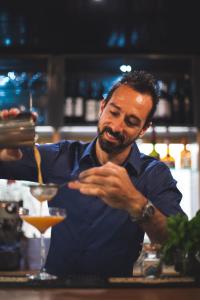 a man standing behind a bar preparing a drink at The Corner London City in London