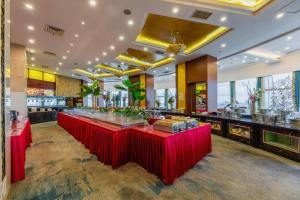 a bar in a restaurant with red tables at Nanchang Oriscene Garden Hotel in Nanchang