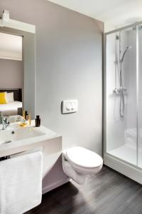 a bathroom with a toilet and a sink and a shower at ibis Styles Roanne Centre Gare in Roanne +94 photos