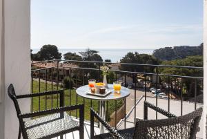 Hotel Eetu Begur, Affiliated by Meliá في بيغور: طاولة مع كأسين من عصير البرتقال على شرفة