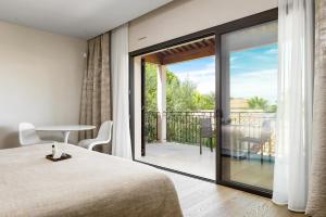 a bedroom with a bed and a balcony with a view at Villa Cosy, hotel & spa in Saint-Tropez