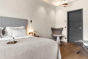 a bedroom with a large bed and a chair at Villa Cosy, hotel & spa in Saint-Tropez