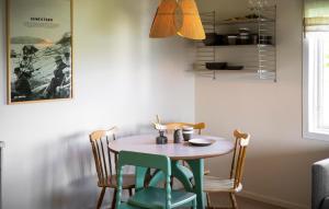 a dining room table with four chairs and a table and a lamp at Cozy Home In Myggenäs With Sauna in Höviksnäs