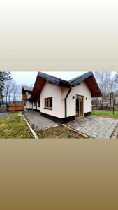 a small white house with a black roof at Miejscówka Werlas in Werlas