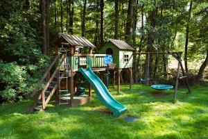 a playground with a slide and a play house at Brzuchem do góry in Chocieszow