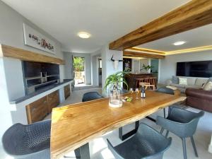 una cucina e un soggiorno con tavolo e sedie in legno di Salt & Soul a Herolds Bay