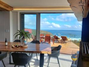 una sala da pranzo con tavolo e vista sull'oceano di Salt & Soul a Herolds Bay