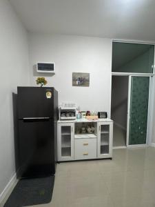 Una pequeña cocina con un refrigerador negro en una habitación. en Sai's cozy house, en Ban Thung O