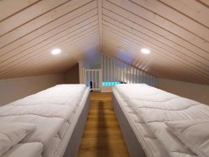 due grandi letti bianchi in una stanza con pavimenti in legno di Saarimaja a Syöte