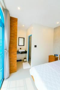 a bedroom with a white bed and a blue door at KParis Beach Resort in Bình Sơn +39 photos