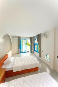 a bedroom with two beds and a window at KParis Beach Resort in Bình Sơn +53 photos
