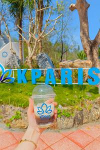 a person holding up a plastic cup with a drink at KParis Beach Resort in Bình Sơn