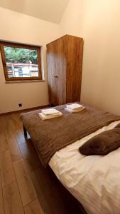 a bedroom with a bed with two towels on it at Miejscówka Werlas in Werlas +41 photos